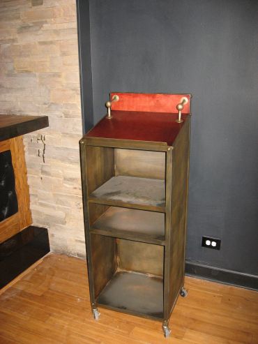 Metal storage shelf on wheels with a red top back panel.