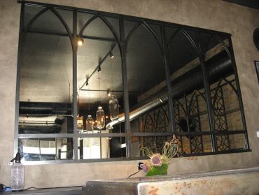 Large decorative wall mirror with arched metal frame.