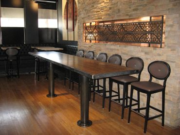 Long wooden table with chairs in a modern room.