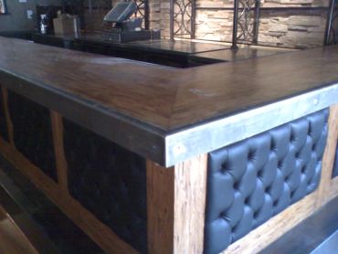 Corner of a modern wooden bar counter.