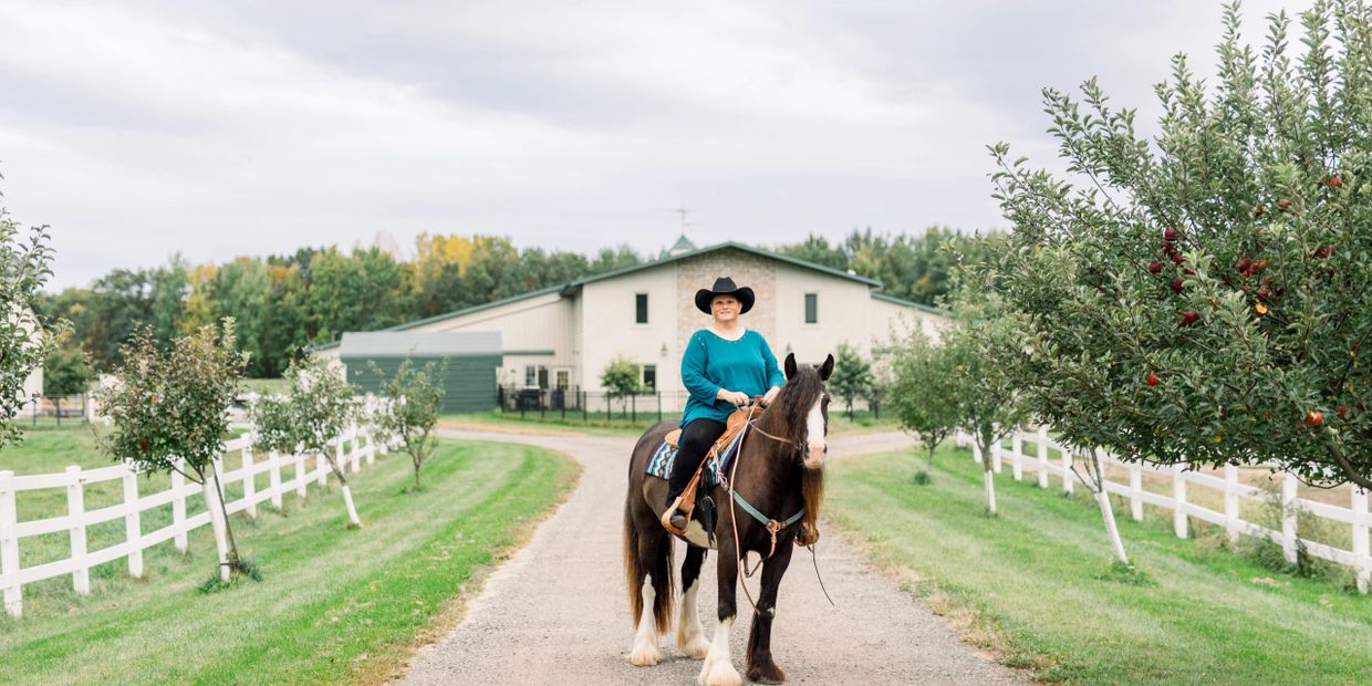 Hale Horse owner Amanda on her black blagdon Gypsy Vanner mare in front of her barn.