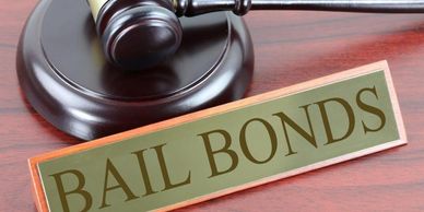 A gavel and a sign reading 'BAIL BONDS' on a wooden surface.