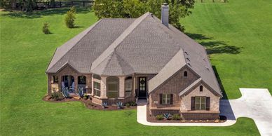 A large brick house with a well-maintained lawn.