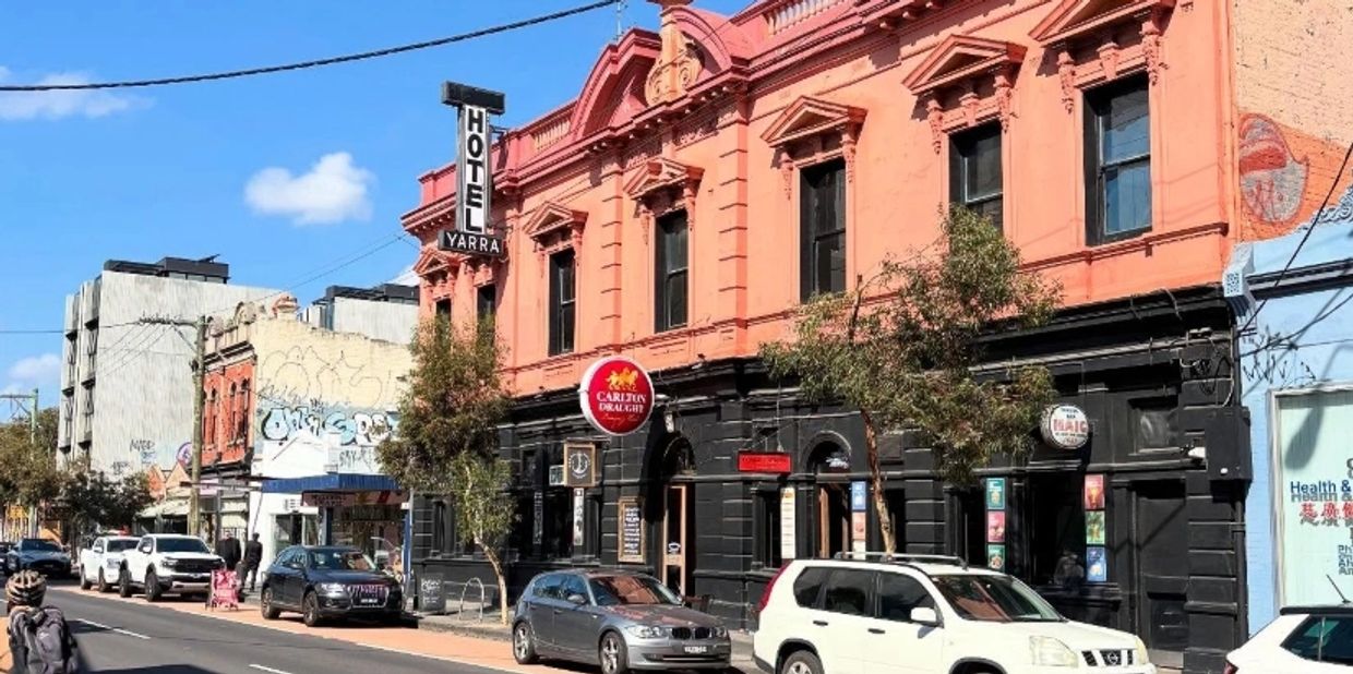 Historic Hotel Yarra with vibrant orange facade on a sunny street.