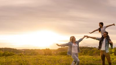 Family enjoying a sunset walk in an open field.