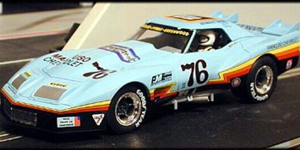 Light blue vintage race car model with number 76 and sponsor decals.
