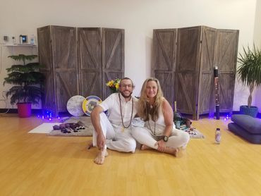 A couple sit on the floor and looking on the camera