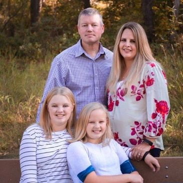Family portrait outdoors on a bench.