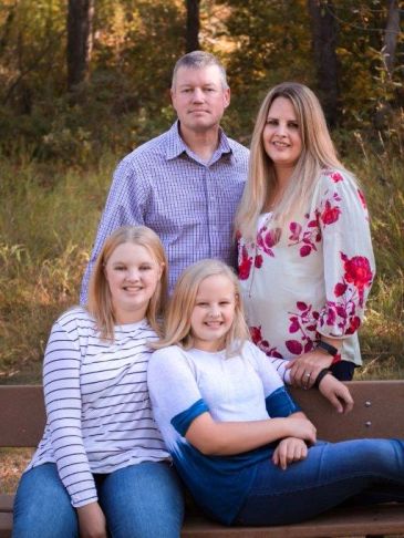 Family portrait outdoors on a bench.