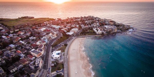 A coastal town at sunset with a beach and ocean.