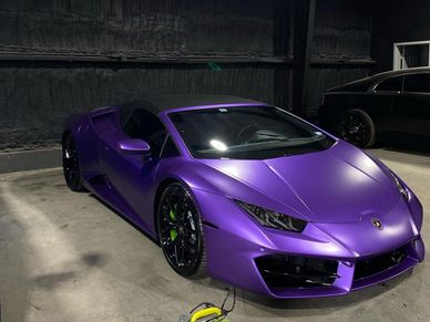 Purple lamborghini sitting in a garage 