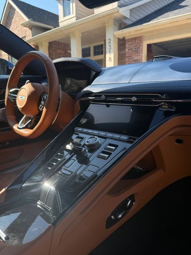 Luxurious car interior with tan leather and advanced control panel.