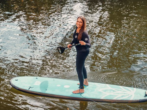 Action surfer gliding on teal board through surf

