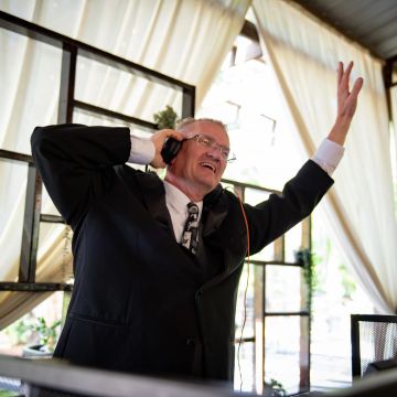 Man in suit enjoying music with headphones indoors.
