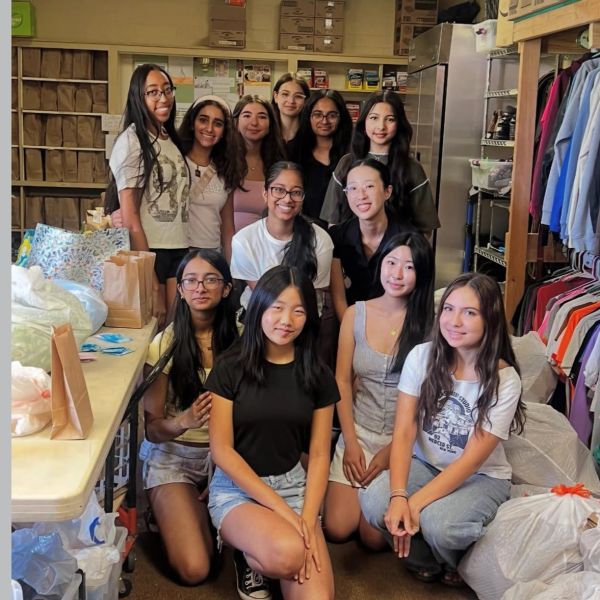 Group of young women posing in a storage room.