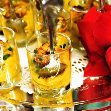 Elegant appetizer in a shot glass with garnish and a spoon.