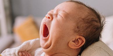 Newborn baby yawning, tired, needs to sleep