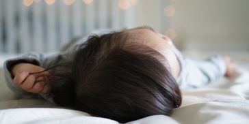 child sleeping in bed with fairy lights