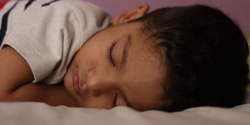 Little boy toddler asleep in bed