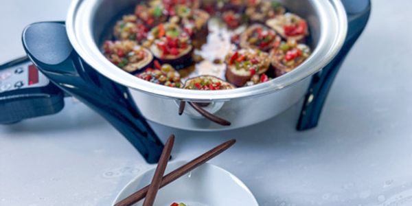 Steamed stuffed mushrooms in a pot with chopsticks on the side.