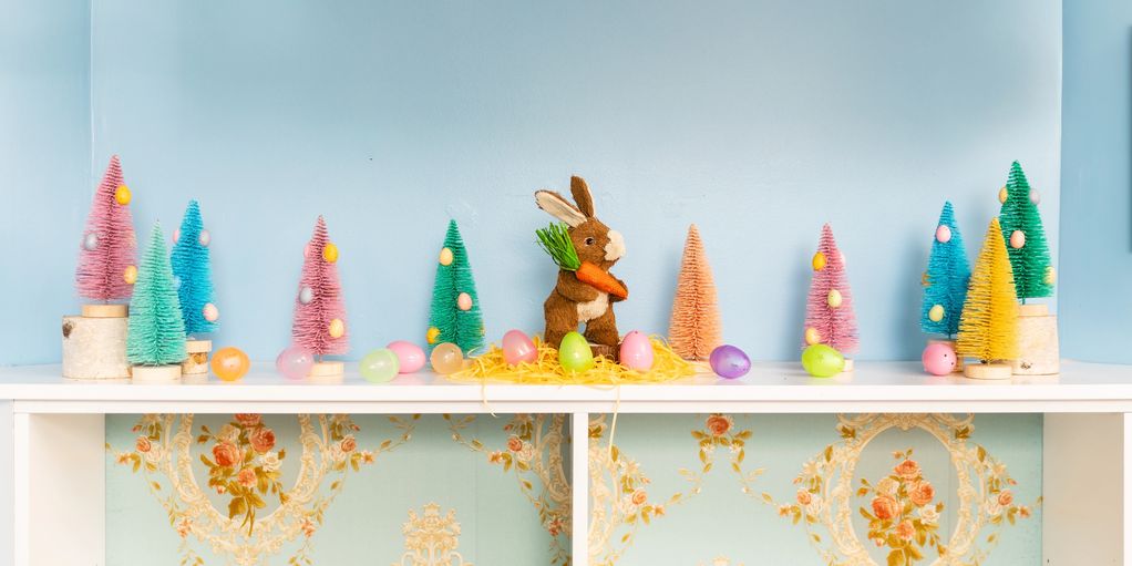 Easter bunny and plastic eggs decoration on shelf with colorful mini trees.