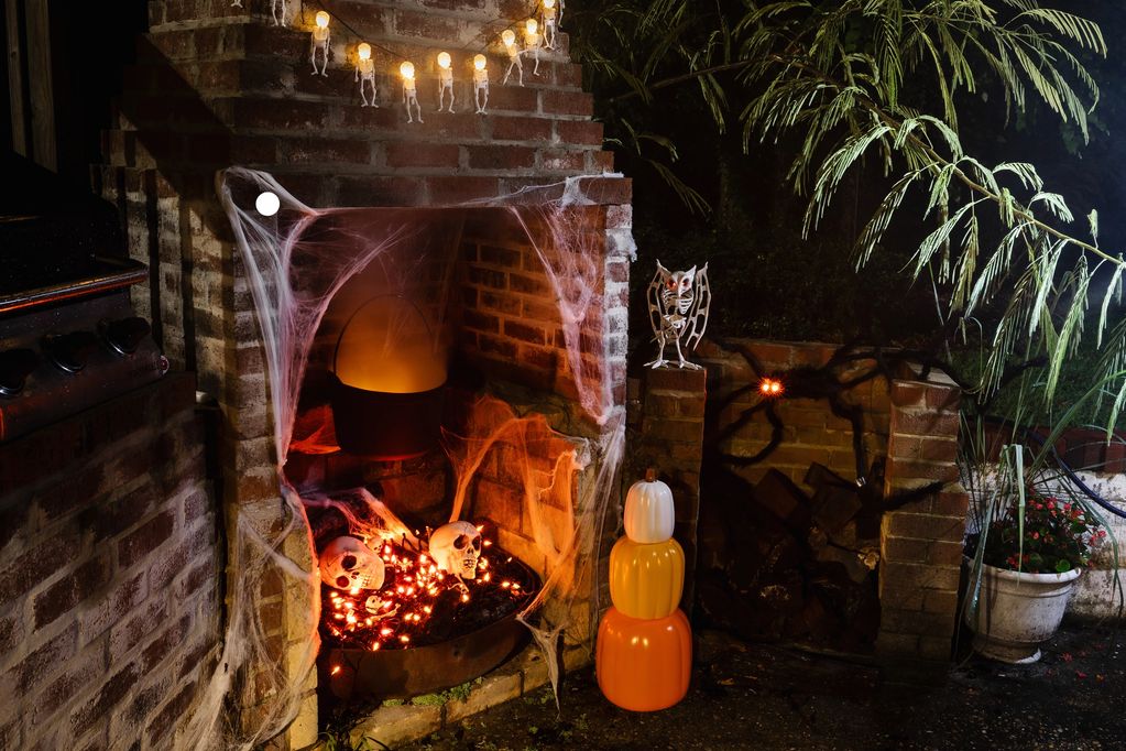 Halloween fireplace with skulls and spooky decorations.