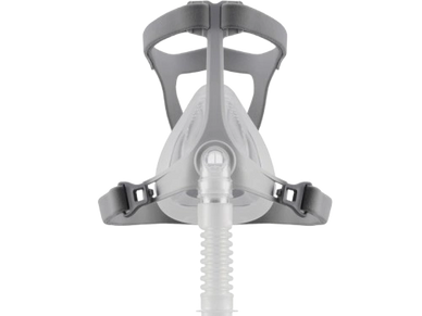 Front view of a white CPAP mask with gray straps and a hose attachment.