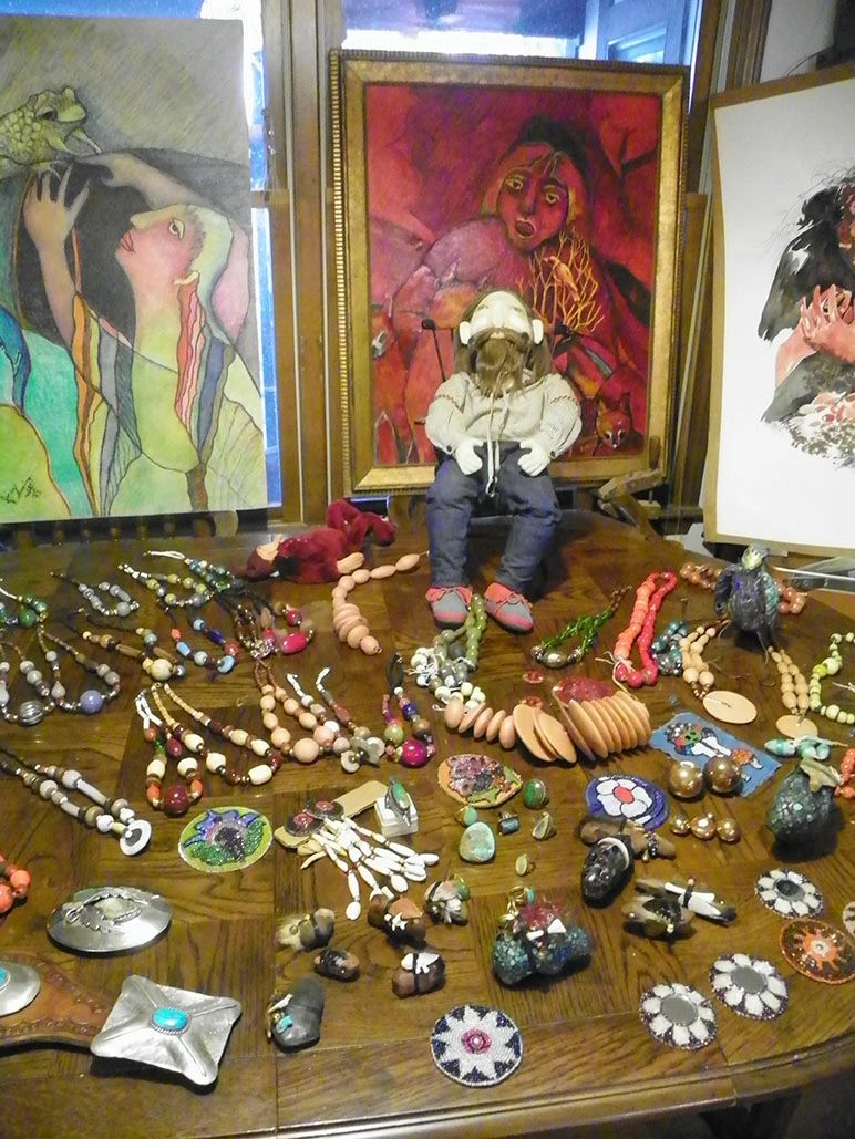 Photo of display of Inez Running-rabbit's artwork including jewelry and her doll "The Poet".