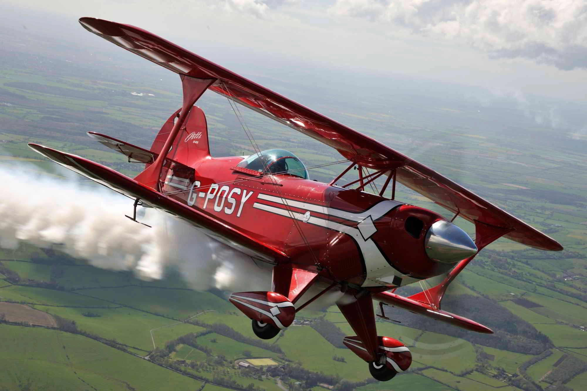 Red Pitts Special biplane performing an aerial maneuver with smoke trail.