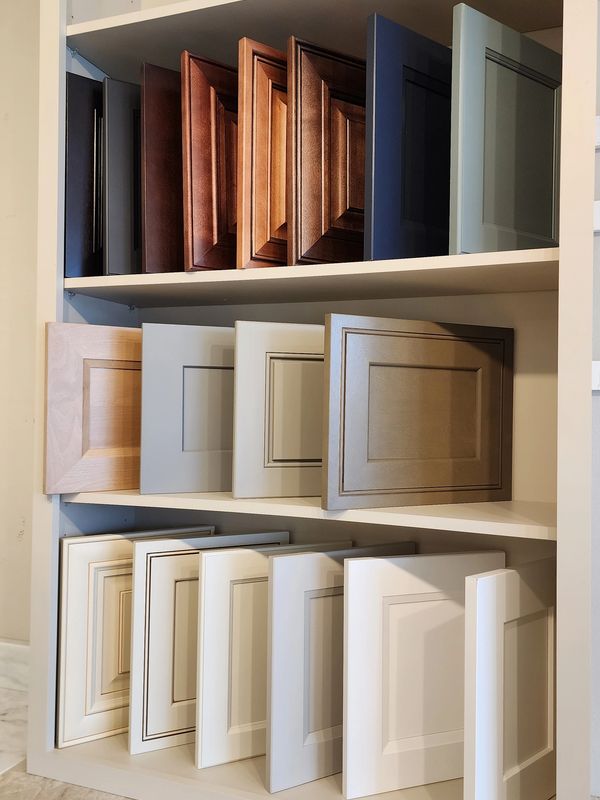 Various cabinet door samples in different colors and finishes on display shelves.