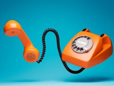 Classic orange rotary phone with handset off-hook.