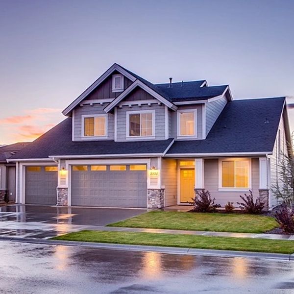 Modern two-story house with a three-car garage at sunset.