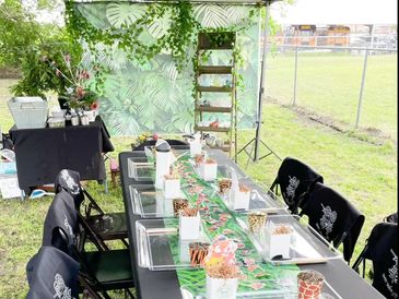 Outdoor My Plant Wagon Plant Bar setup with planters, supplies and a table prepared for guests.