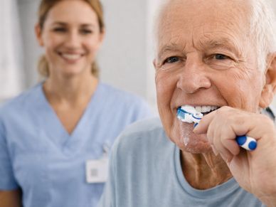 elderly man brushing his teeth