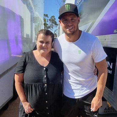woman standing with cam waters race car driver