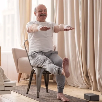 Un homme âgé fait de l'exercice en étant assis sur une chaise.