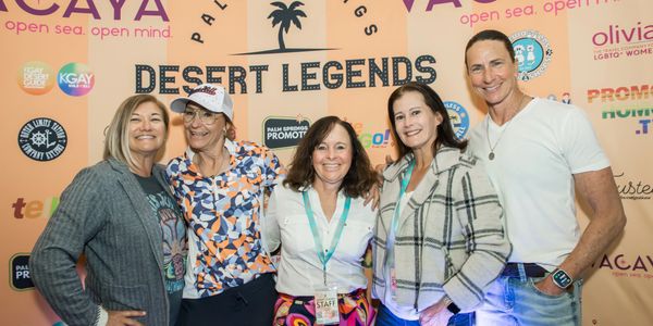 Group of five smiling people posing at Desert Legends event.