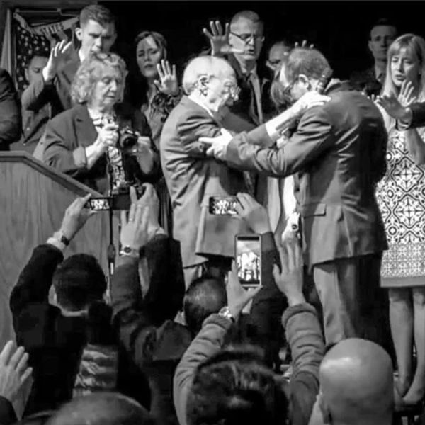People praying and capturing a moment during a ceremony or event.