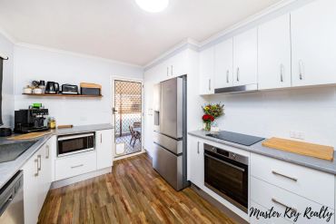 Modern kitchen with white cabinetry and stainless steel appliances.