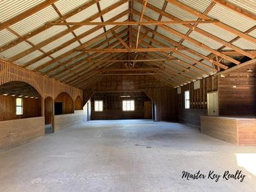 Spacious empty wooden interior with high ceiling and large windows.