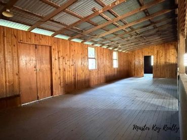 Empty spacious wooden room with natural light and rustic charm.