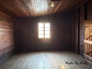Empty wooden room with light from a window illuminating the space.