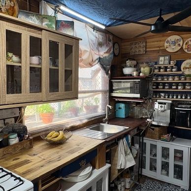 Cozy rustic kitchen with wooden counters and vintage decor.