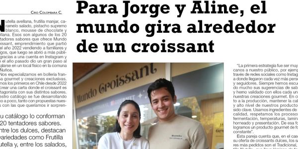 Jorge and Aline stand smiling in front of Mundo Croissant bakery sign.