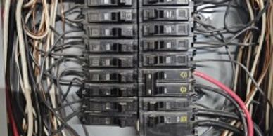 Electrical circuit breakers and wiring inside a panel.