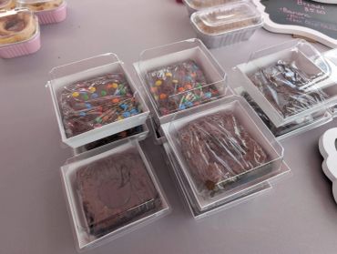Assorted brownies in clear plastic boxes.