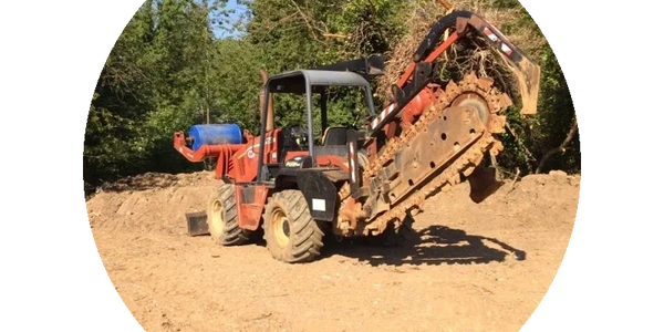 A red trencher machine on a dirt field just got back from repair.
