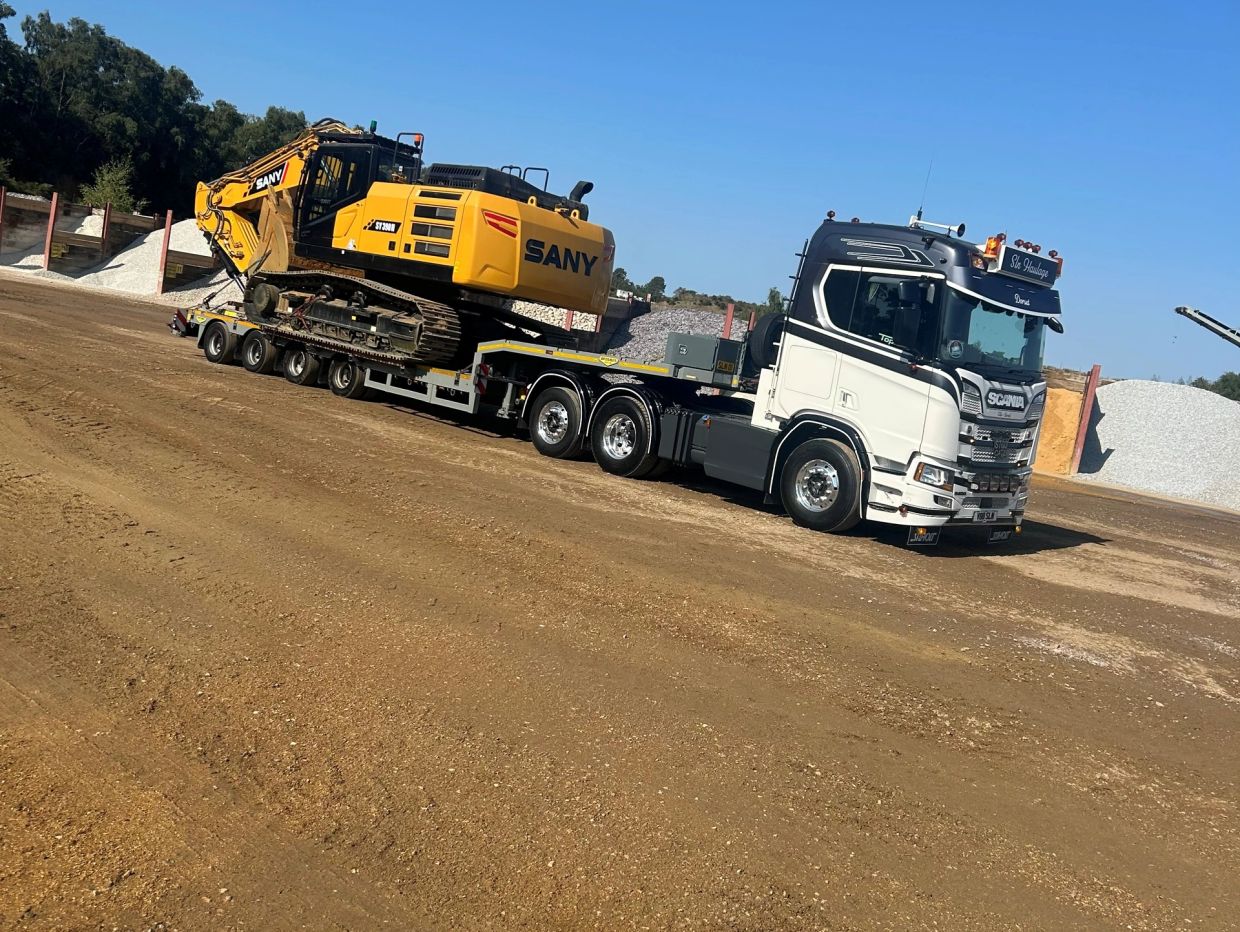 Heavy machinery being transported on a flatbed truck.