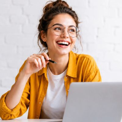 Jeune femme souriante travaillant sur un ordinateur portable.