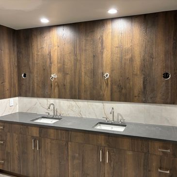 Modern bathroom vanity with double sinks and wood-paneled walls.